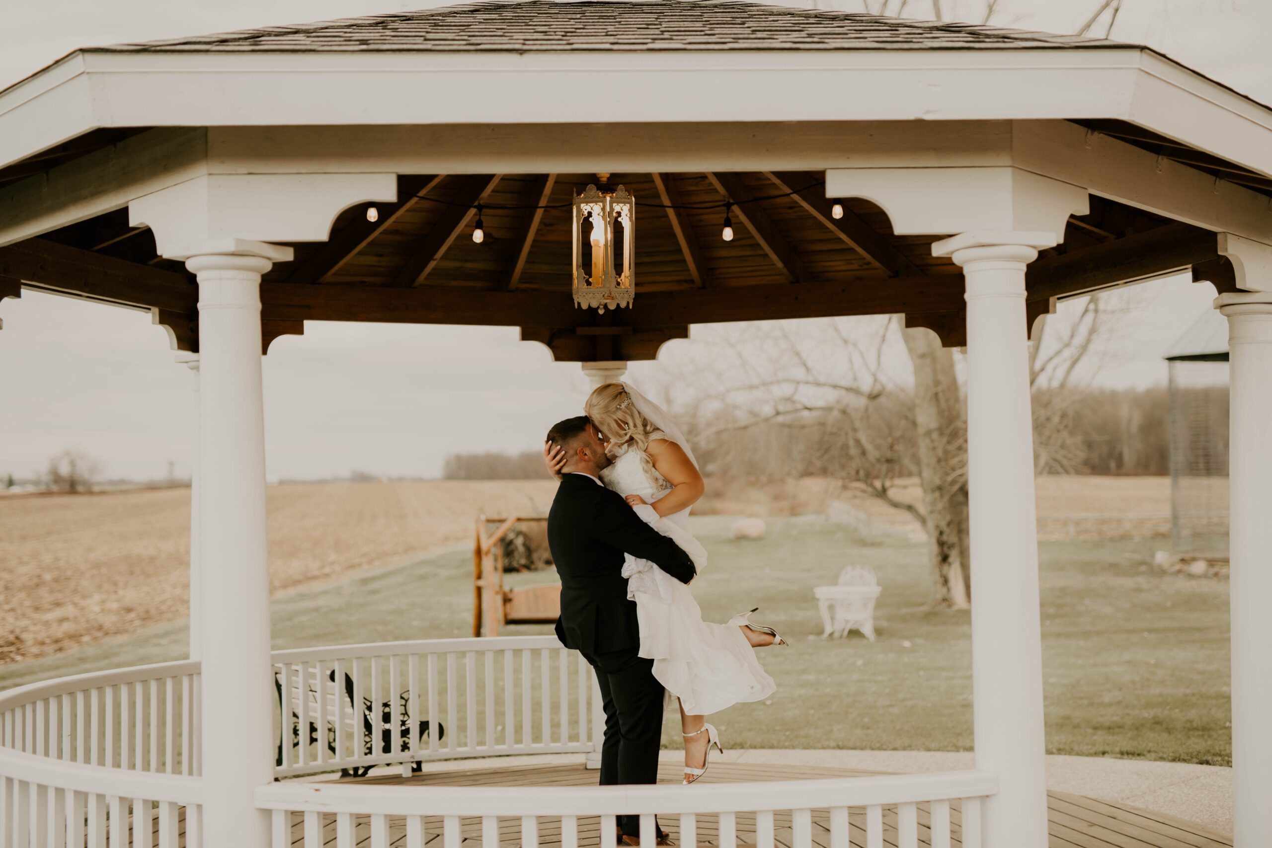 couple hugging under a gazebo after their Michigan wedding ceremony
